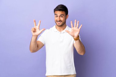 Mor arka planda izole edilmiş genç ve yakışıklı bir adam.