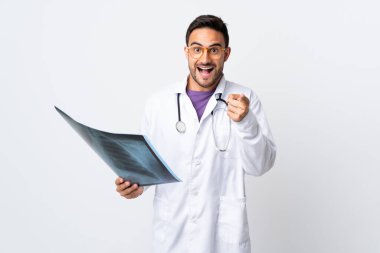 Genç doktor elinde beyaz arka planda izole edilmiş bir radyografi tutuyor.