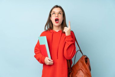 Mavi arka planda izole edilmiş kitapları tutan öğrenci kız işaret parmağıyla işaret etmek harika bir fikir.