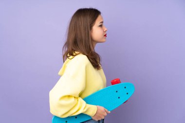 Mor arka planda paten kayan genç bir kız.