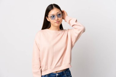 Genç Çinli kız izole edilmiş beyaz arka plan bir fikir düşünüyor.