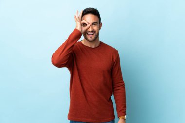 Tecrit edilmiş genç ve yakışıklı bir adam parmaklarıyla işaret veriyor.