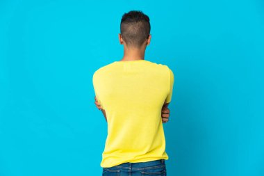 Genç Brezilyalı adam arka planda mavi arka planda izole edilmiş.