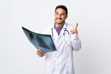 Genç doktor elinde beyaz arka planda izole edilmiş bir radyografi tutuyor.