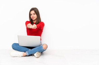 Beyaz arkaplan üzerinde bilgisayar ile çalışan tenaager kız bir reklam eklemek için avuç içi hayali kopyalama alanı tutuyor