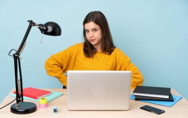 Öğrenci kız evinde çalışıyor. Mavi arka planda izole edilmiş. Öfkeli.