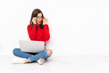 Polisle çalışan hassas kız beyaz arka planda gözlüklü ve şaşırmış.