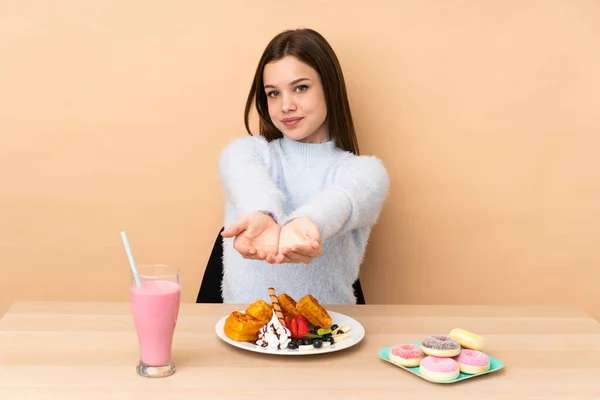 Chica Adolescente Comiendo Gofres Aislados Sobre Fondo Beige Sosteniendo Espacio —  Fotos de Stock