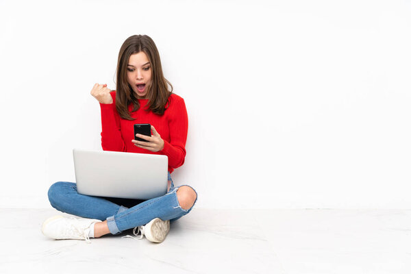 Tenaager girl working with pc isolated on white background surprised and sending a message