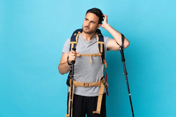 Jovem Caucasiano Com Mochila Postes Trekking Isolados Fundo Azul Com — Fotografia de Stock