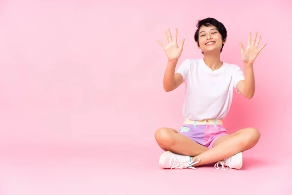 Young Vietnamese Woman Short Hair Sitting Floor Isolated Pink Background — Stock Photo, Image