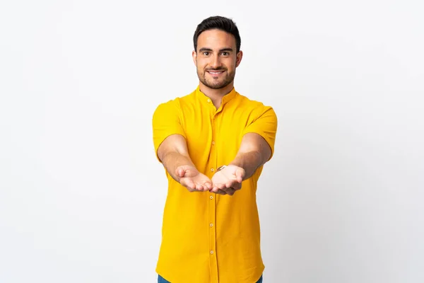 Joven Hombre Guapo Sobre Fondo Aislado Sosteniendo Espacio Copia Imaginario —  Fotos de Stock