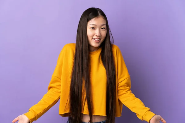 年轻的中国姑娘在孤寂的紫色背景上快乐而微笑 — 图库照片