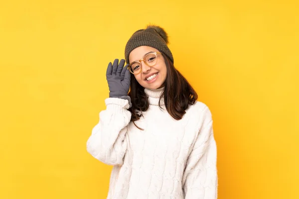 戴着冬帽的年轻女子 戴着眼镜 背对着孤立的黄色背景 快乐极了 — 图库照片