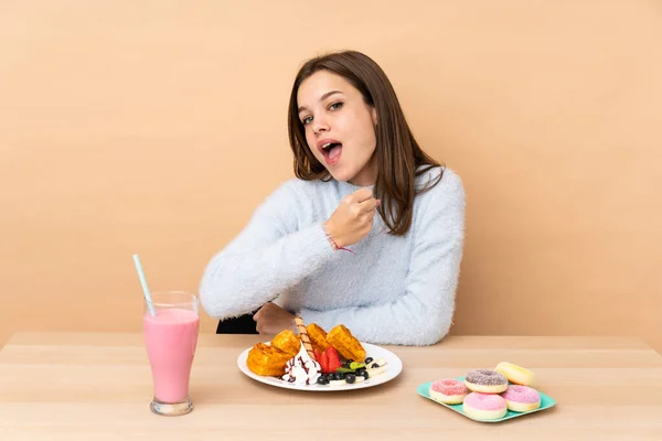 Chica Adolescente Comiendo Gofres Aislados Sobre Fondo Beige Celebrando Una —  Fotos de Stock