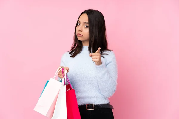 Jonge Vrouw Met Boodschappentas Geïsoleerde Roze Achtergrond Gefrustreerd Wijzen Naar — Stockfoto