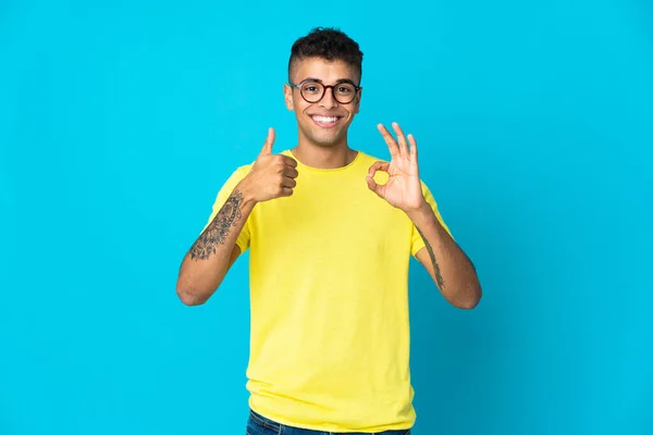 Jovem Brasileiro Isolado Fundo Azul Mostrando Sinal Polegar Para Cima — Fotografia de Stock