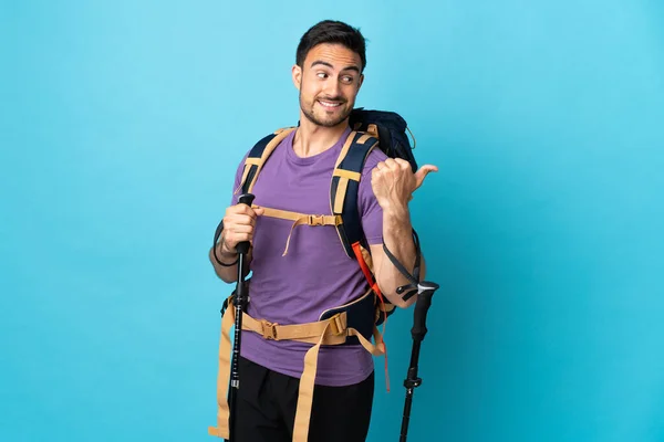 Homem Caucasiano Jovem Com Mochila Postes Trekking Isolados Fundo Azul — Fotografia de Stock