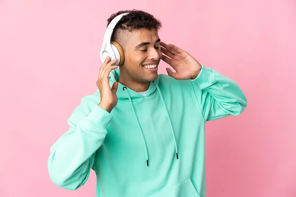 Jonge Braziliaanse Man Geïsoleerd Roze Achtergrond Luisteren Muziek Zingen — Stockfoto