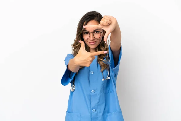 隔離された白い壁の焦点面の上の若い外科医の医者の女性 フレーミングシンボル — ストック写真