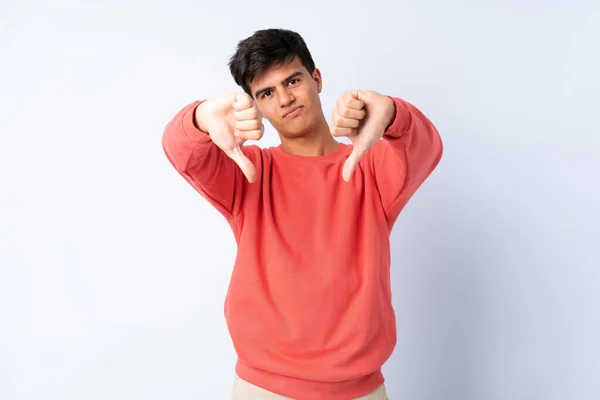 Hombre Guapo Sobre Fondo Azul Aislado Mostrando Pulgar Hacia Abajo —  Fotos de Stock