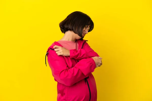 年轻孕妇在孤立的黄色背景上 肘部疼痛 — 图库照片