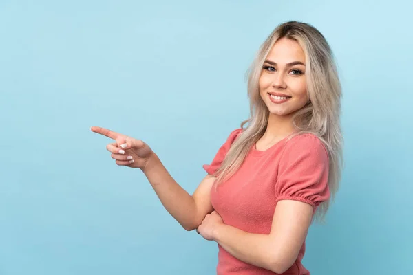 Tonårstjej Över Isolerad Blå Bakgrund Pekar Finger Sidan — Stockfoto