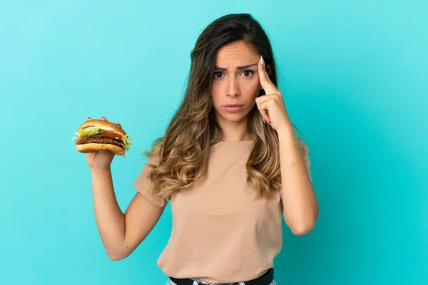 Jeune Femme Tenant Hamburger Sur Fond Isolé Penser Une Idée — Photo
