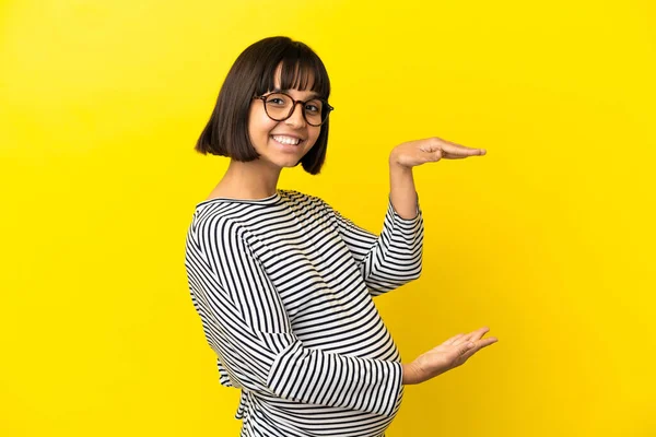 若いです妊娠中の女性以上隔離された黄色の背景保持コピースペースへ挿入する広告 — ストック写真