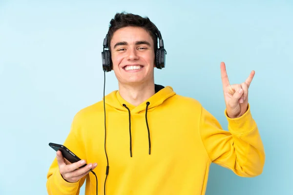 Adolescente Caucasiano Homem Isolado Fundo Roxo Ouvir Música Com Móvel — Fotografia de Stock