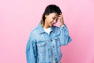 Genç Uruguaylı kadın pembe arka planda gülüyor.