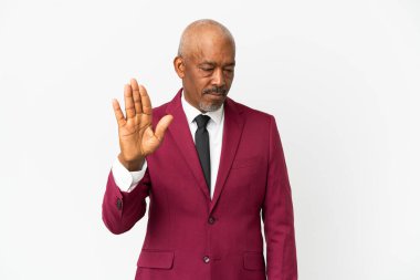 Kübalı son sınıf öğrencisi beyaz arka planda izole edilmiş. Durma hareketi yapıyor ve hayal kırıklığı yaşıyor