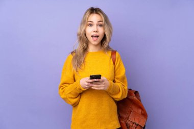 Mor arka planda izole edilmiş genç Rus öğrenci şaşırdı ve bir mesaj gönderiyor.