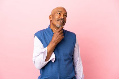 Kübalı son sınıf öğrencisi pembe arka planda izole edilmiş ve araştırılıyor