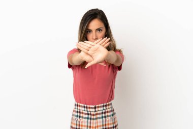 Tecrit edilmiş genç bir kadın bir eylemi durdurmak için el hareketini durduruyor.