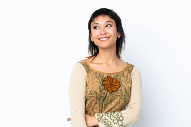 Genç Uruguaylı kız izole edilmiş beyaz arka planda gülümserken yukarı bakıyor