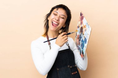 Soyutlanmış arka planda palet tutan genç sanatçı.