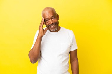 Kübalı kıdemli izole edilmiş sarı arka planda gülüyor