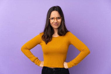 Mor arka planda izole edilmiş öfkeli genç bir ırk kadını.