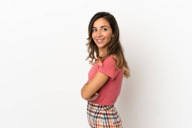 İzole edilmiş arka planda genç bir kadın yana bakıyor ve gülümsüyor.