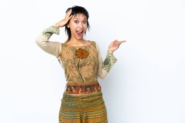 Genç Uruguaylı kız izole edilmiş beyaz arka planda şaşkın şaşkın ve parmağıyla kenarı işaret ediyor