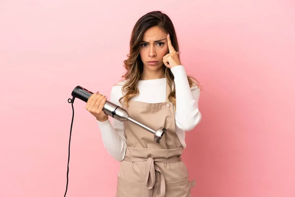 Jovem Mulher Usando Liquidificador Mão Sobre Fundo Rosa Isolado Pensando — Fotografia de Stock