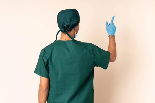 Surgeon Man Blue Uniform Isolated Background Pointing Back Index Finger — Foto de Stock