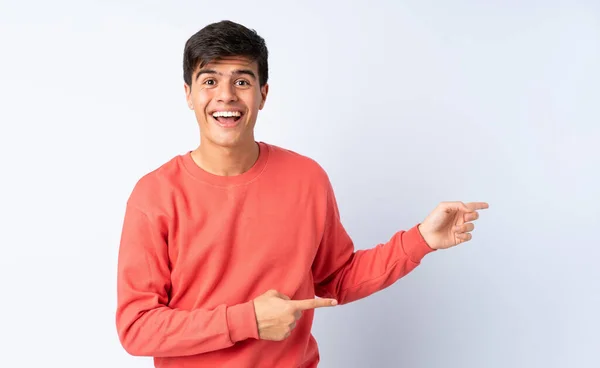 Hombre Guapo Sobre Fondo Azul Aislado Sorprendido Apuntando Lado —  Fotos de Stock