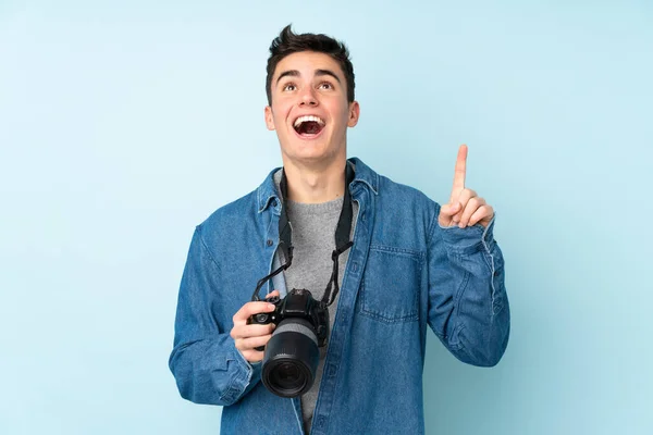 Teenager Photographer Man Isolated Blue Background Pointing Index Finger Great — Stock Photo, Image