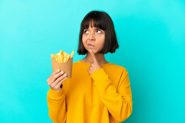 Joven Morena Sosteniendo Chips Fritos Sobre Fondo Azul Aislado Teniendo — Foto de Stock