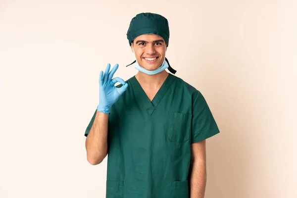 身穿蓝色制服的外科医生 背景孤立 手指头上有个好的标志 — 图库照片