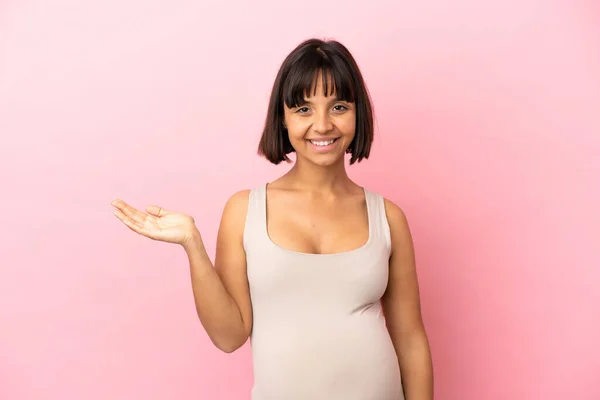 Jovem Grávida Sobre Fundo Rosa Isolado Segurando Copyspace Imaginário Palma — Fotografia de Stock