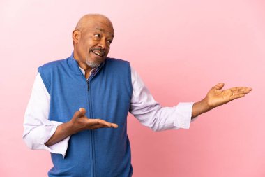 Kübalı son sınıf öğrencisi, pembe arkaplanda sürpriz bir ifadeyle izole edildi.