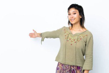 Genç Uruguaylı kız, soyutlanmış beyaz arka planda elini uzatarak davet ediyor.